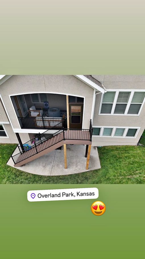 A wooden deck with a metal railing is sitting on top of a house.