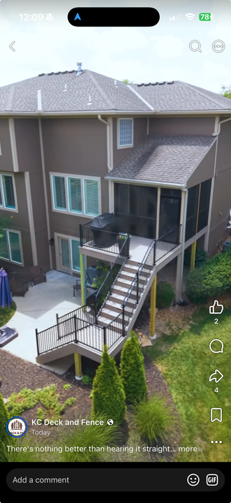 A large wooden deck is sitting in the backyard of a house.