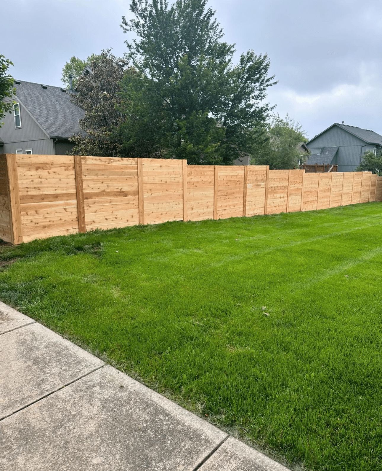 A wooden fence is sitting in the middle of a lush green lawn.