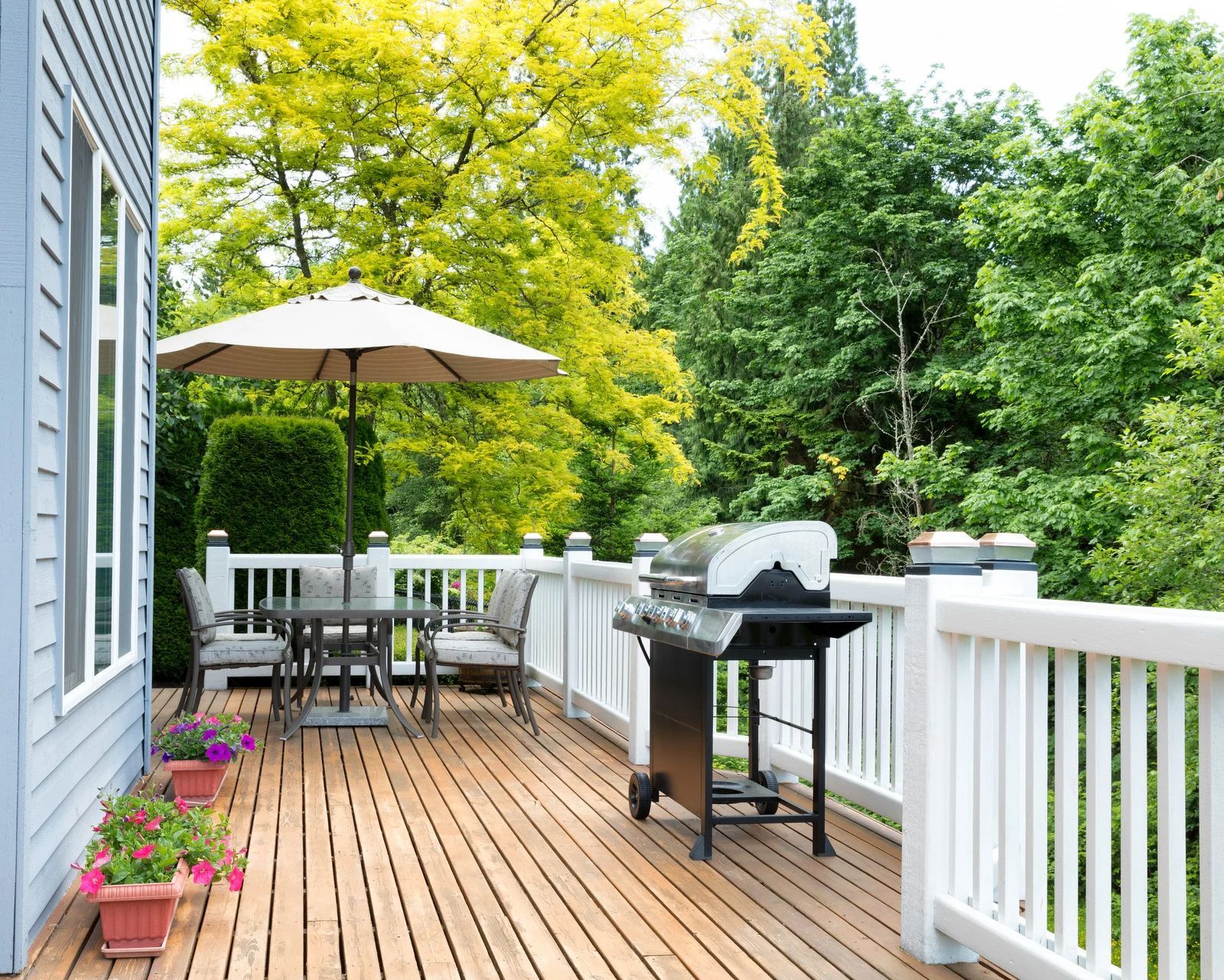 Covered porch with seating; wooden ceiling and floor; views of green foliage.