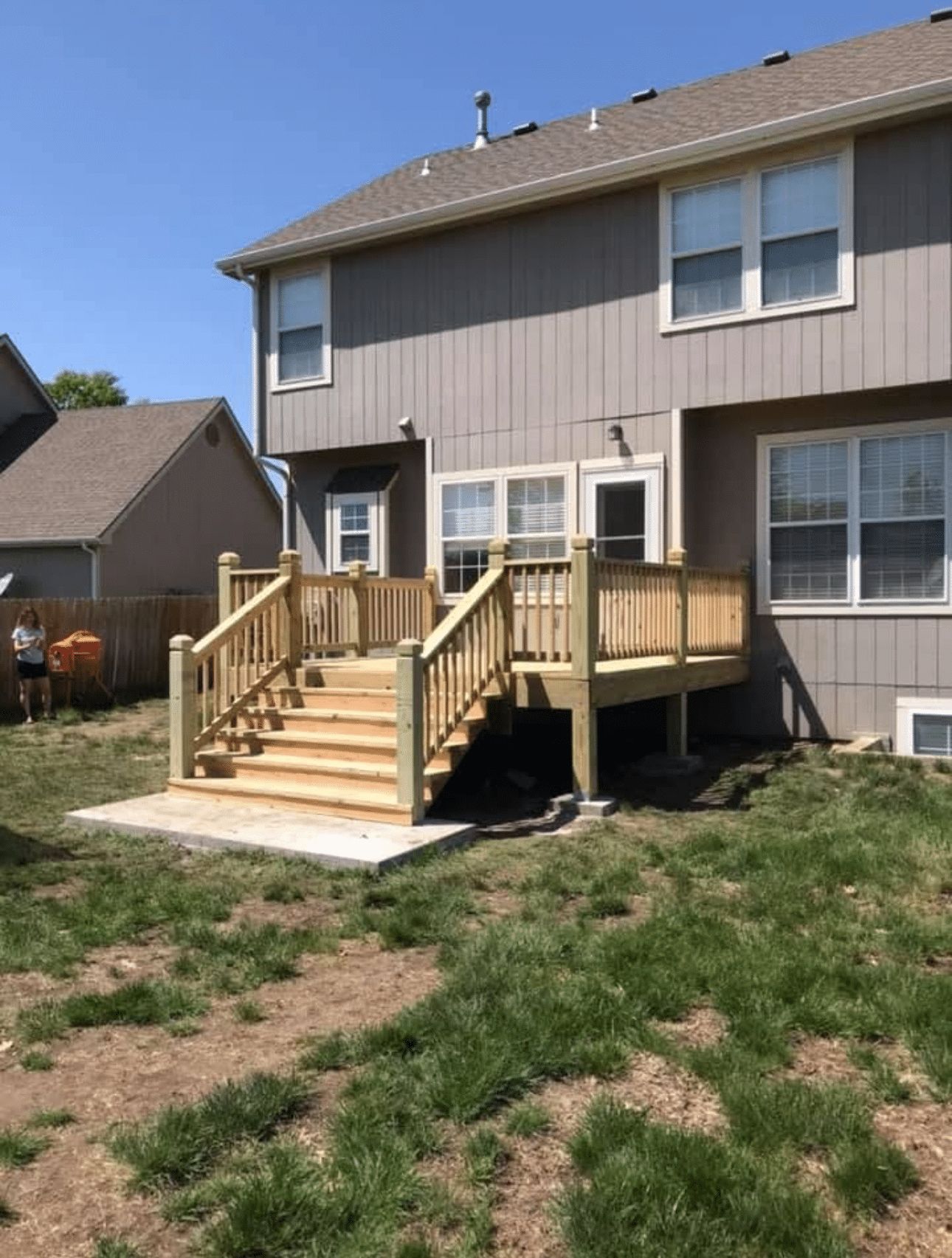 A house with a wooden deck and stairs in the backyard