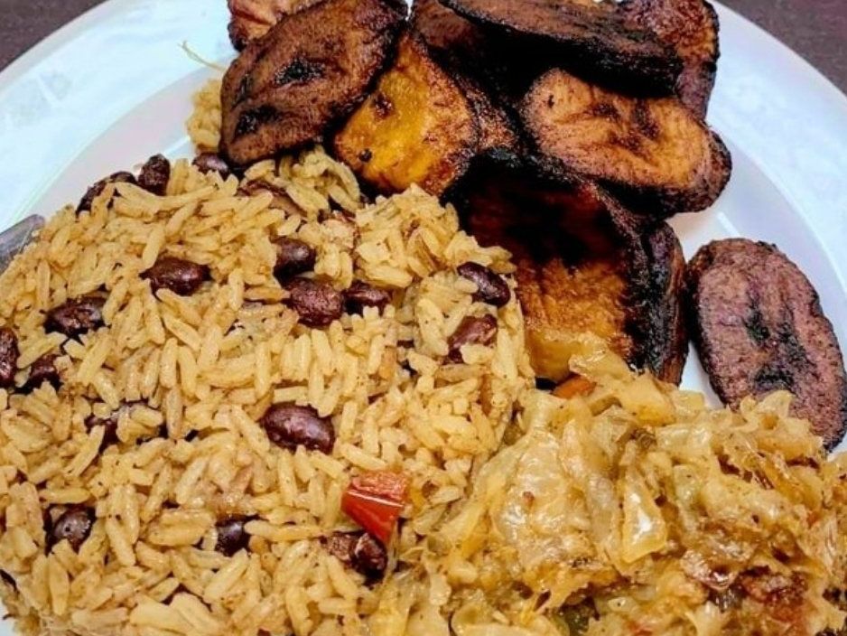 Plate of rice and beans, fried plantains, and sautéed cabbage.
