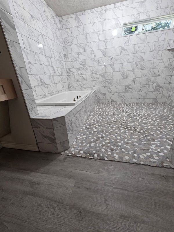 Modern bathroom with a white vanity, gray tile floor, and tiled shower area