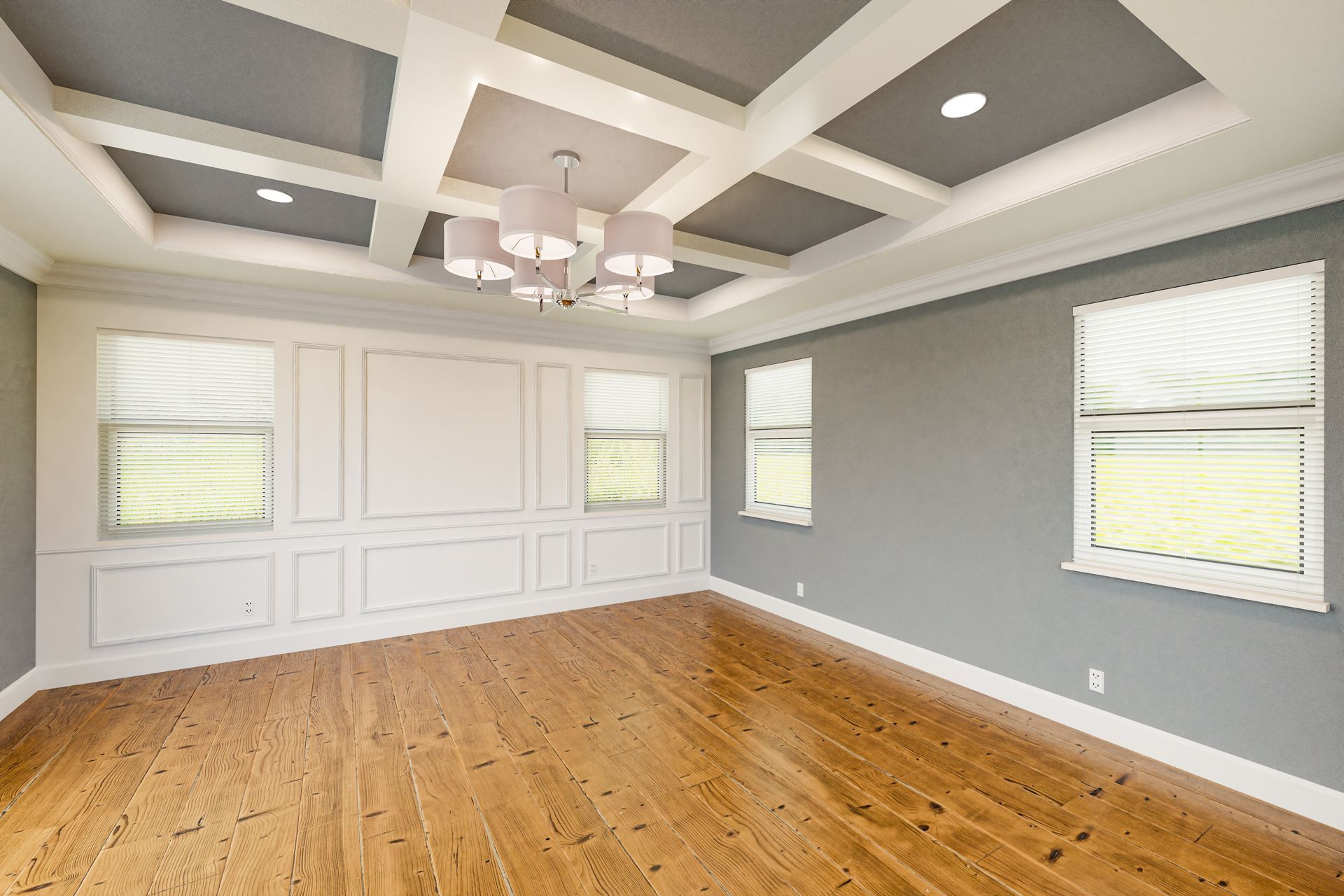 Empty modern room with hardwood floor, gray walls, and a coffered ceiling with a chandelier.