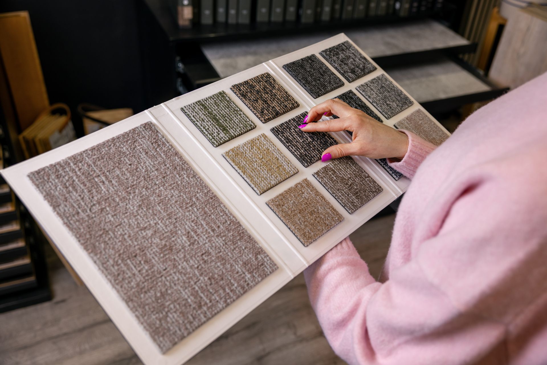 Person in a pink sweater using a magnified reading page with large print text in a library.