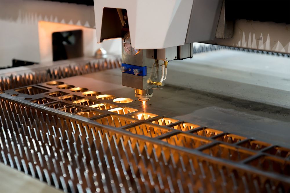 A Machine is Cutting a Piece of Metal on a Table — Total Engraving In Sandgate, NSW