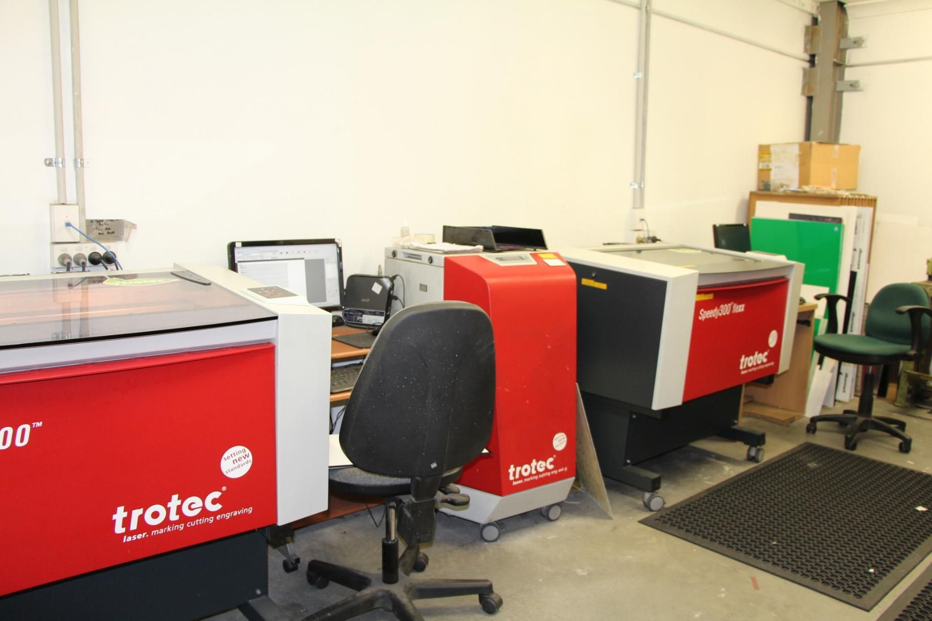 A Row of Trotec Machines Are Lined Up in a Room — Total Engraving In Sandgate, NSW