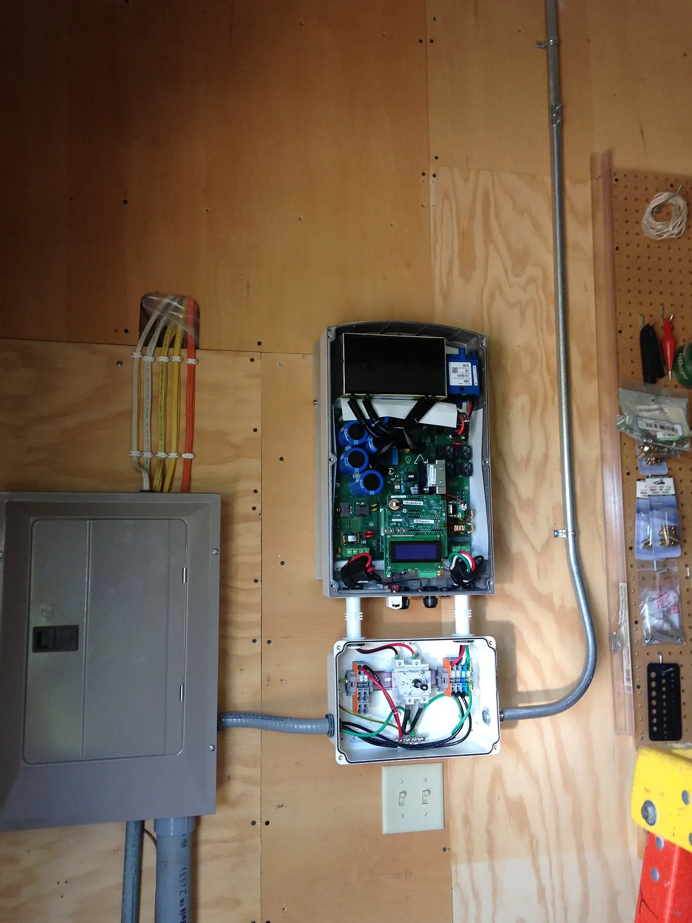 An electrical box is hanging on a wooden wall next to a ladder