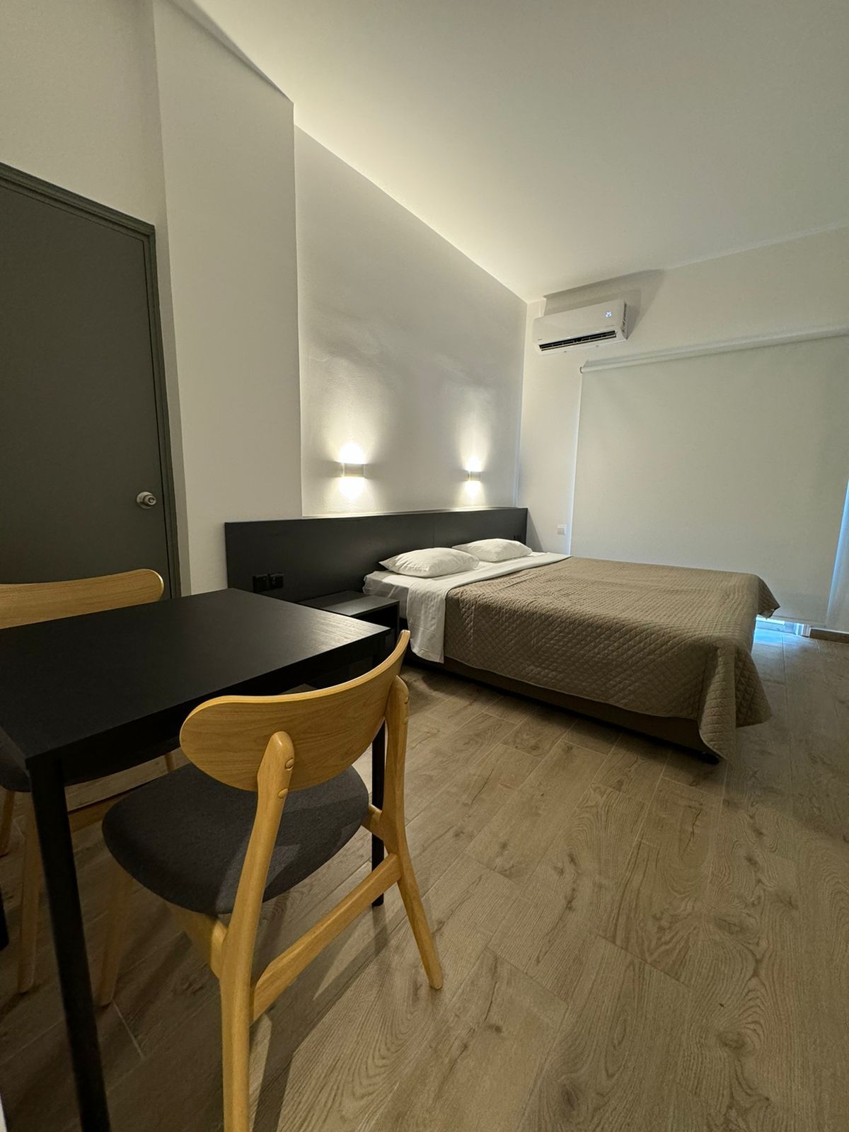 A hotel room with a bed , table and chairs.