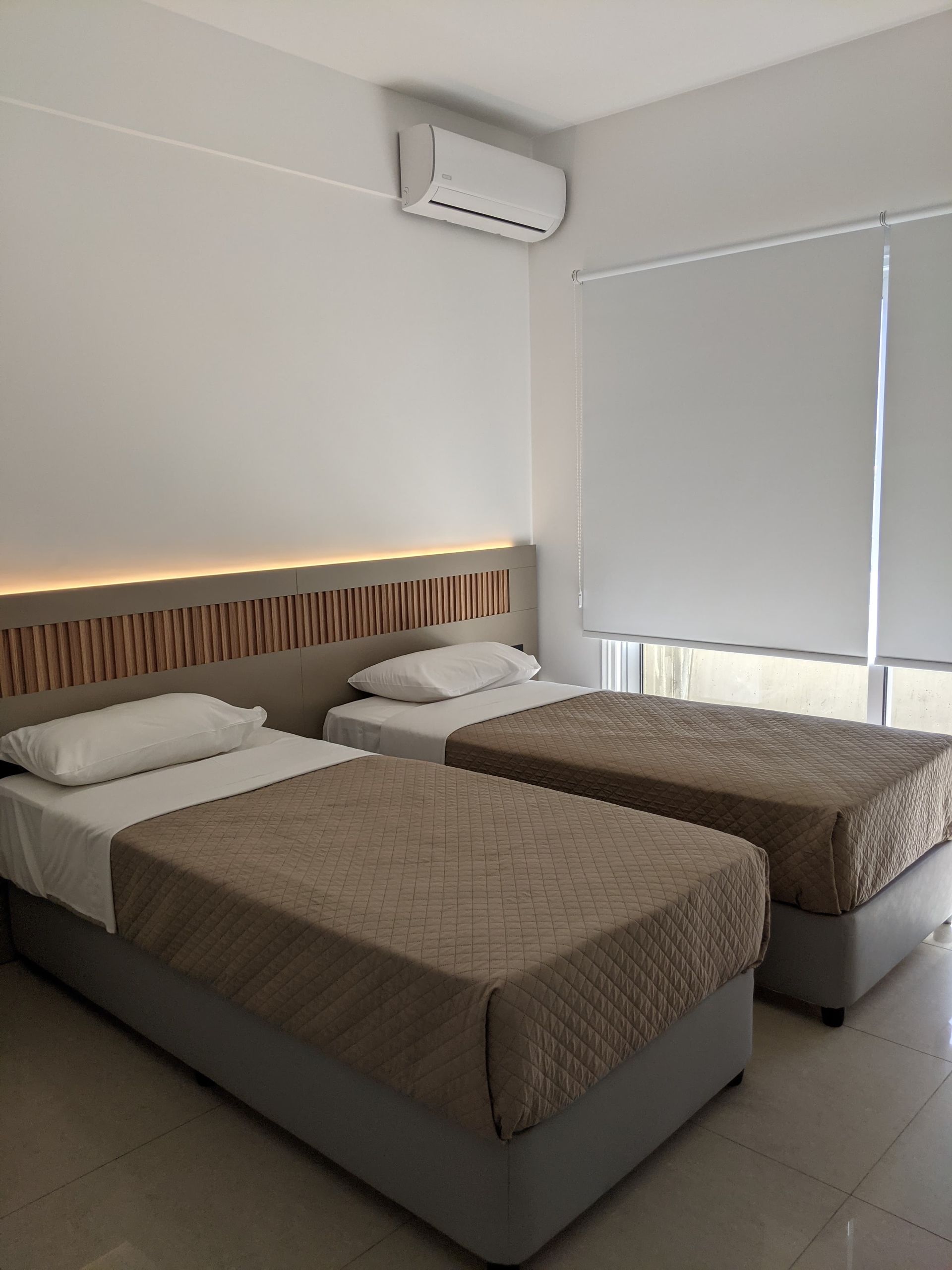 A hotel room with two beds and a window