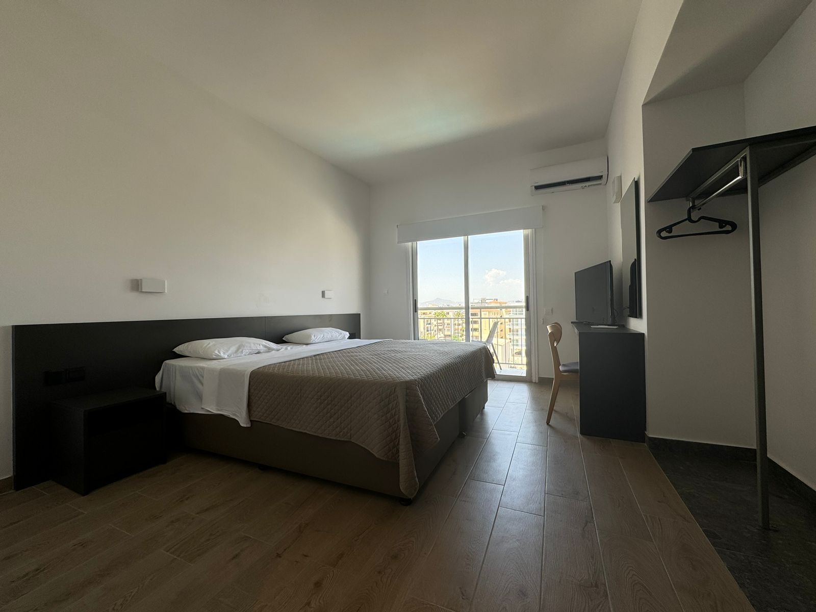 A hotel room with a large bed and a sliding glass door