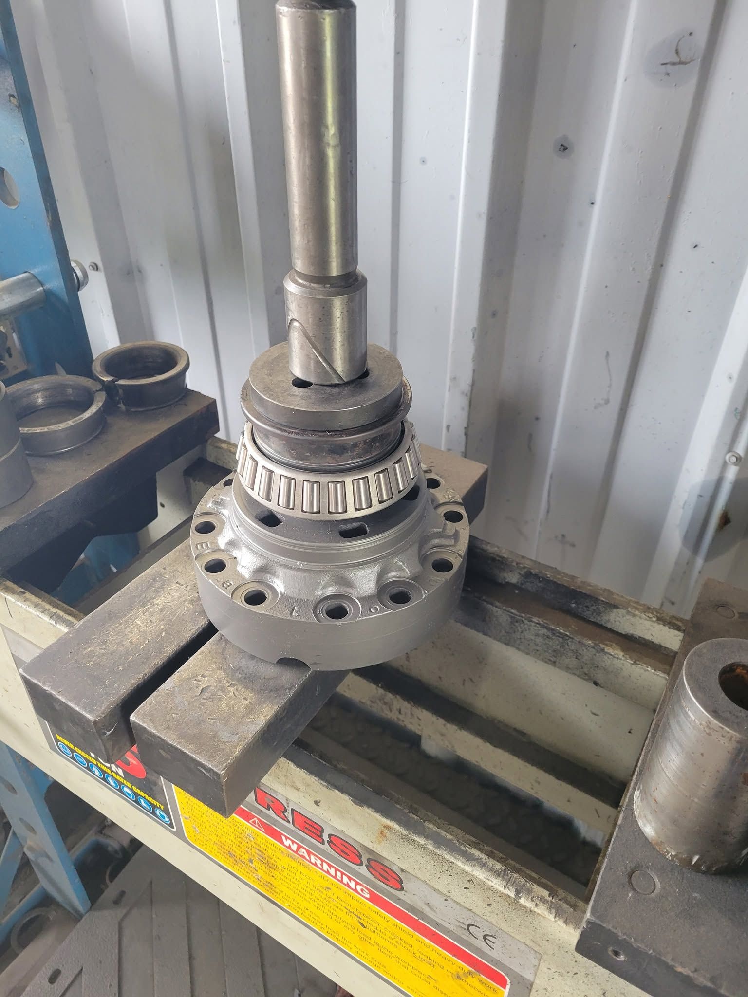 Metal mechanical assembly mounted on a milling machine table in a workshop.