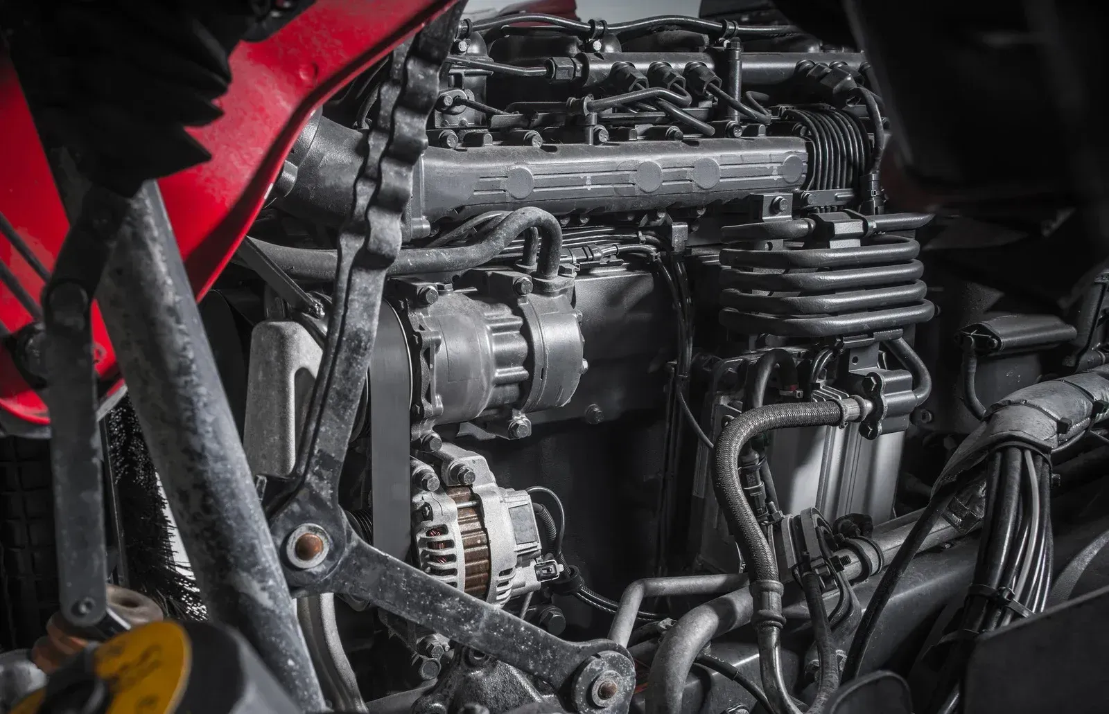 Close-up of a dirt bike engine with black tubing and a red body panel