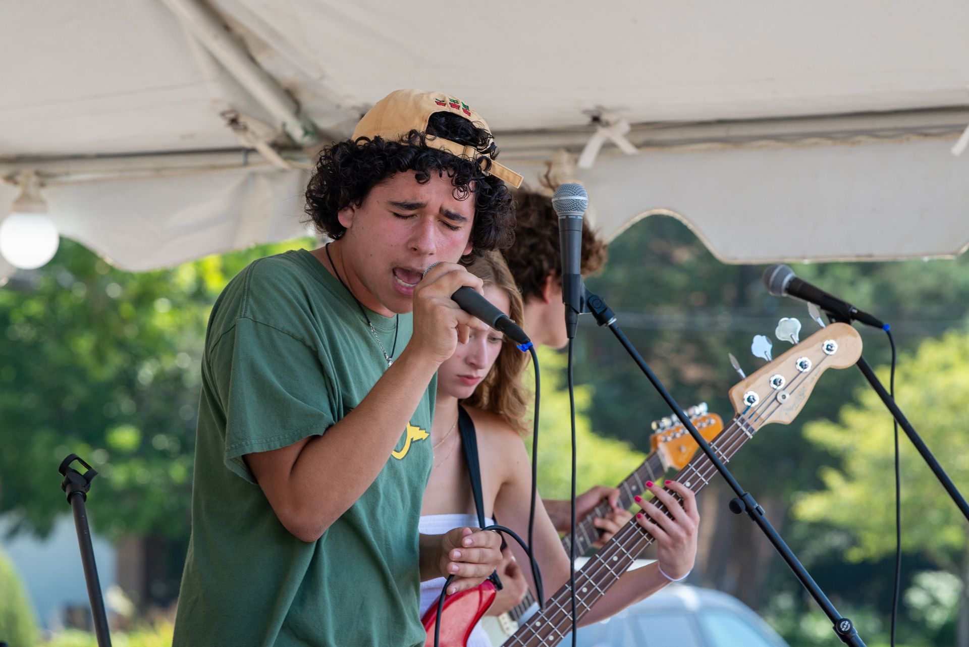 A man is singing into a microphone while a woman plays a guitar.