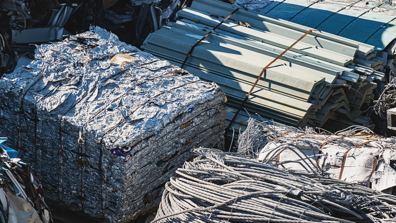 Stacks of crushed metal scrap and bundled debris in an industrial yard