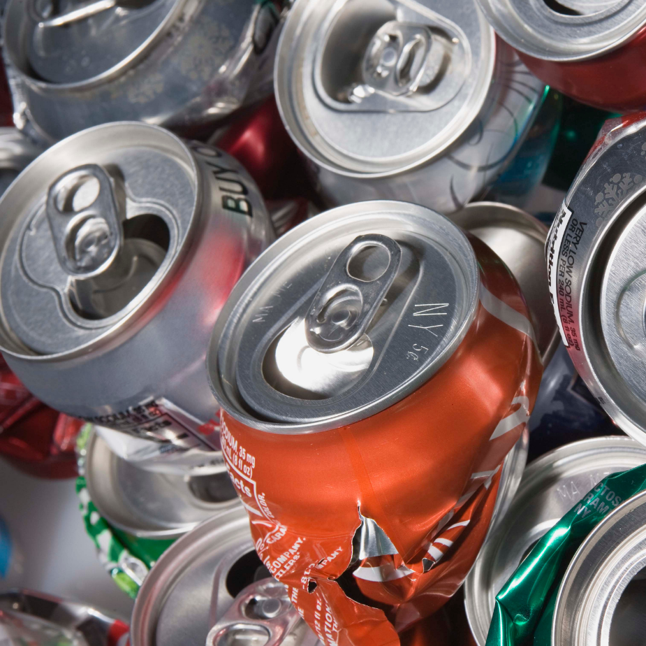 Crushed aluminum soda cans piled together, with silver, red, and green tops visible.