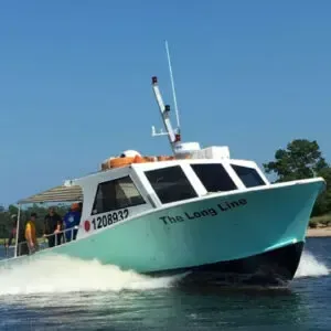 White tour boat named “The Long Line” speeding across blue water under a clear sky