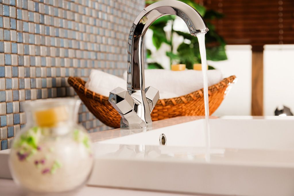 A bathroom sink with water running from the faucet.