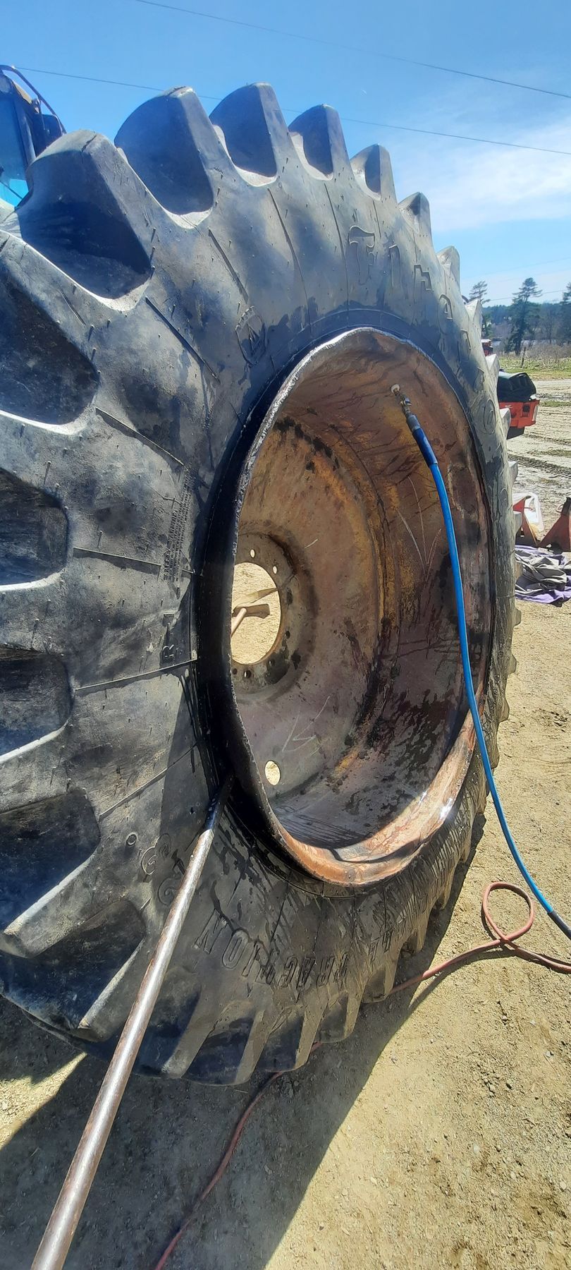 A close up of a tire on a tractor with a hole in it.