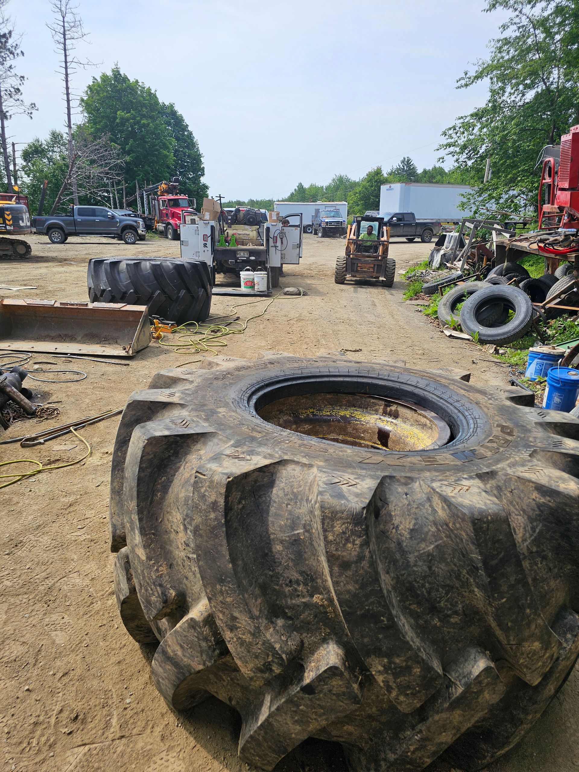 A large tire is sitting in the middle of a dirt field.
