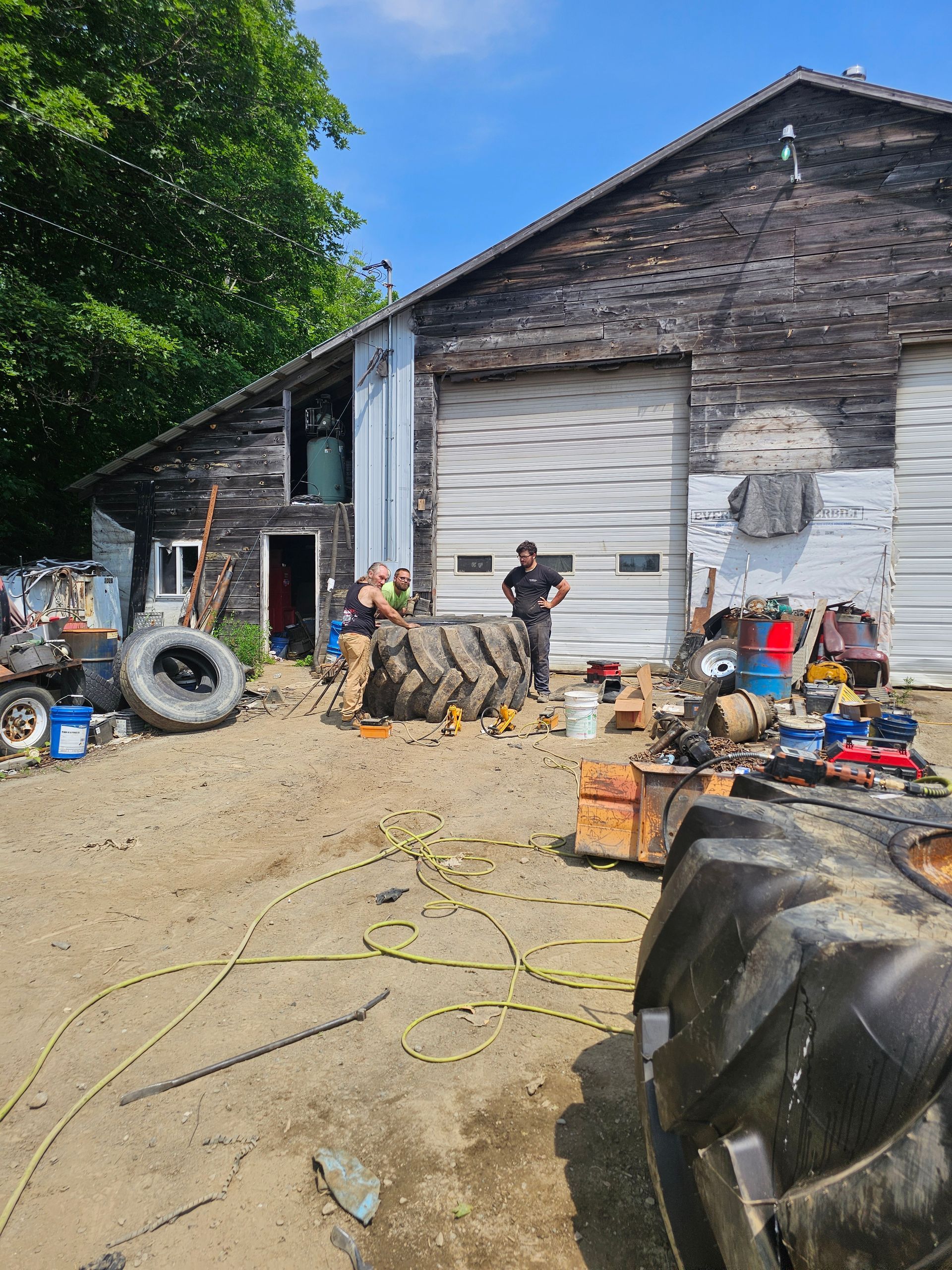 A group of people are standing in front of a barn.