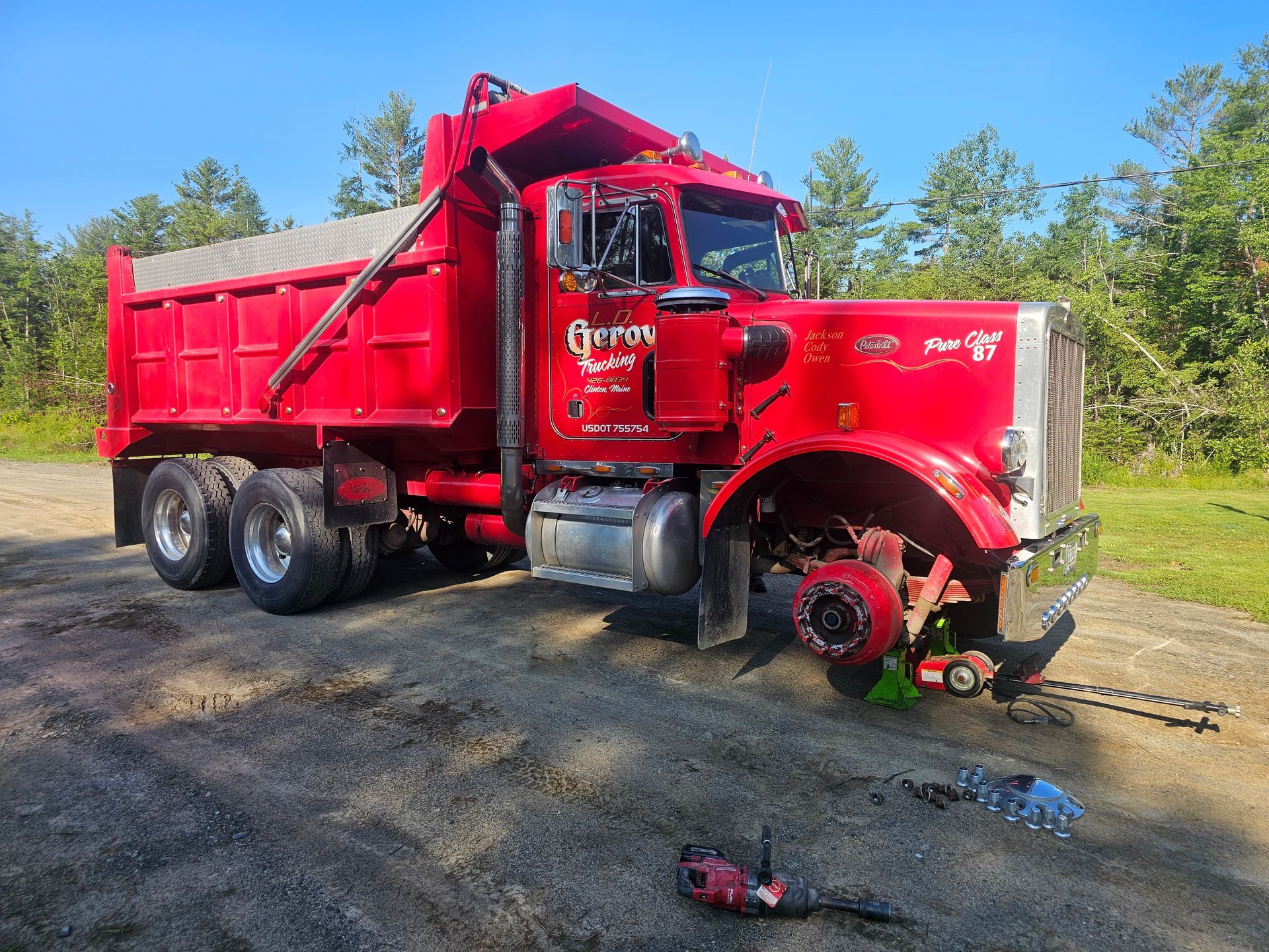 A red dump truck is parked on the side of the road.
