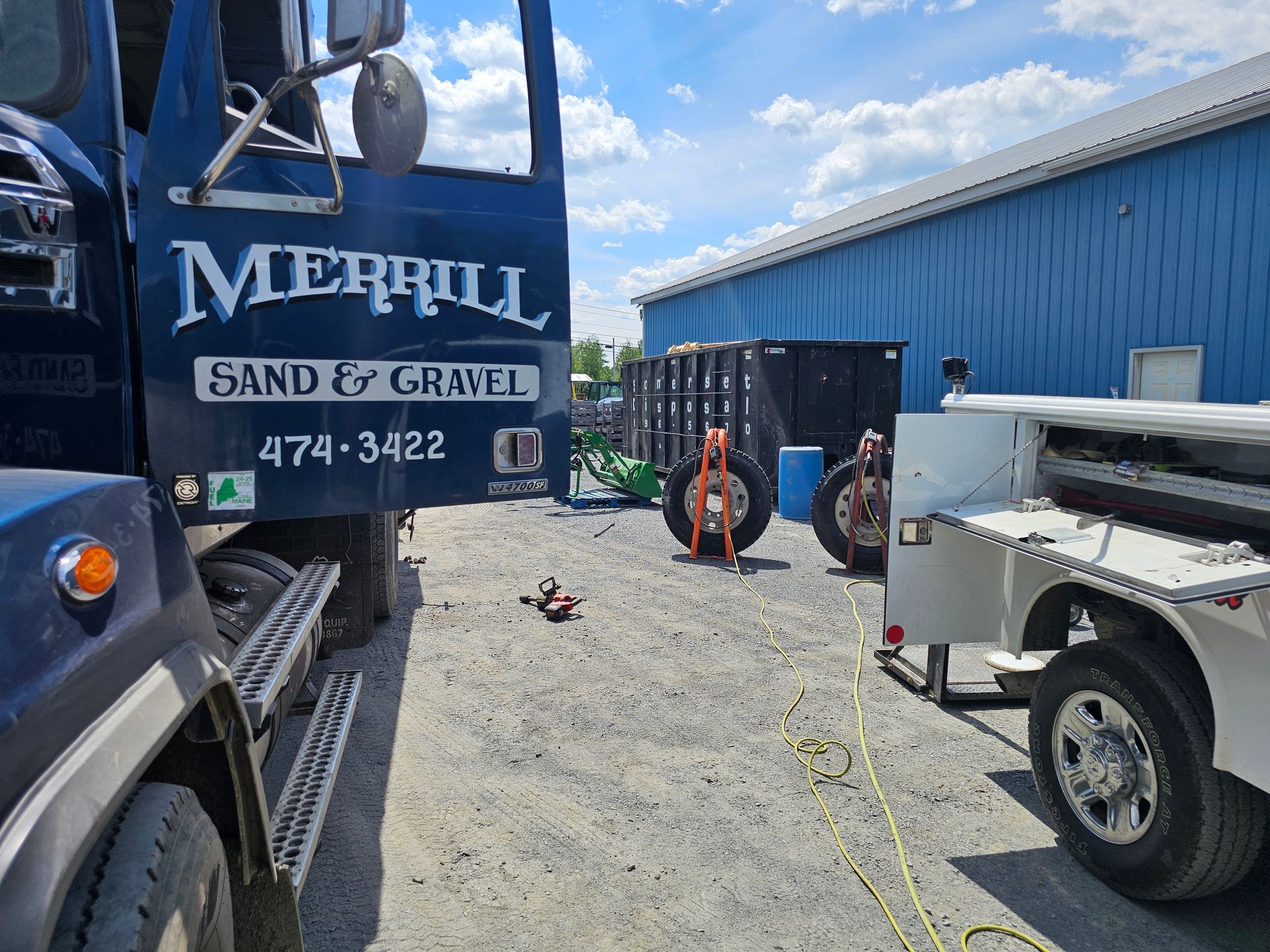 A blue truck is parked in front of a blue building.