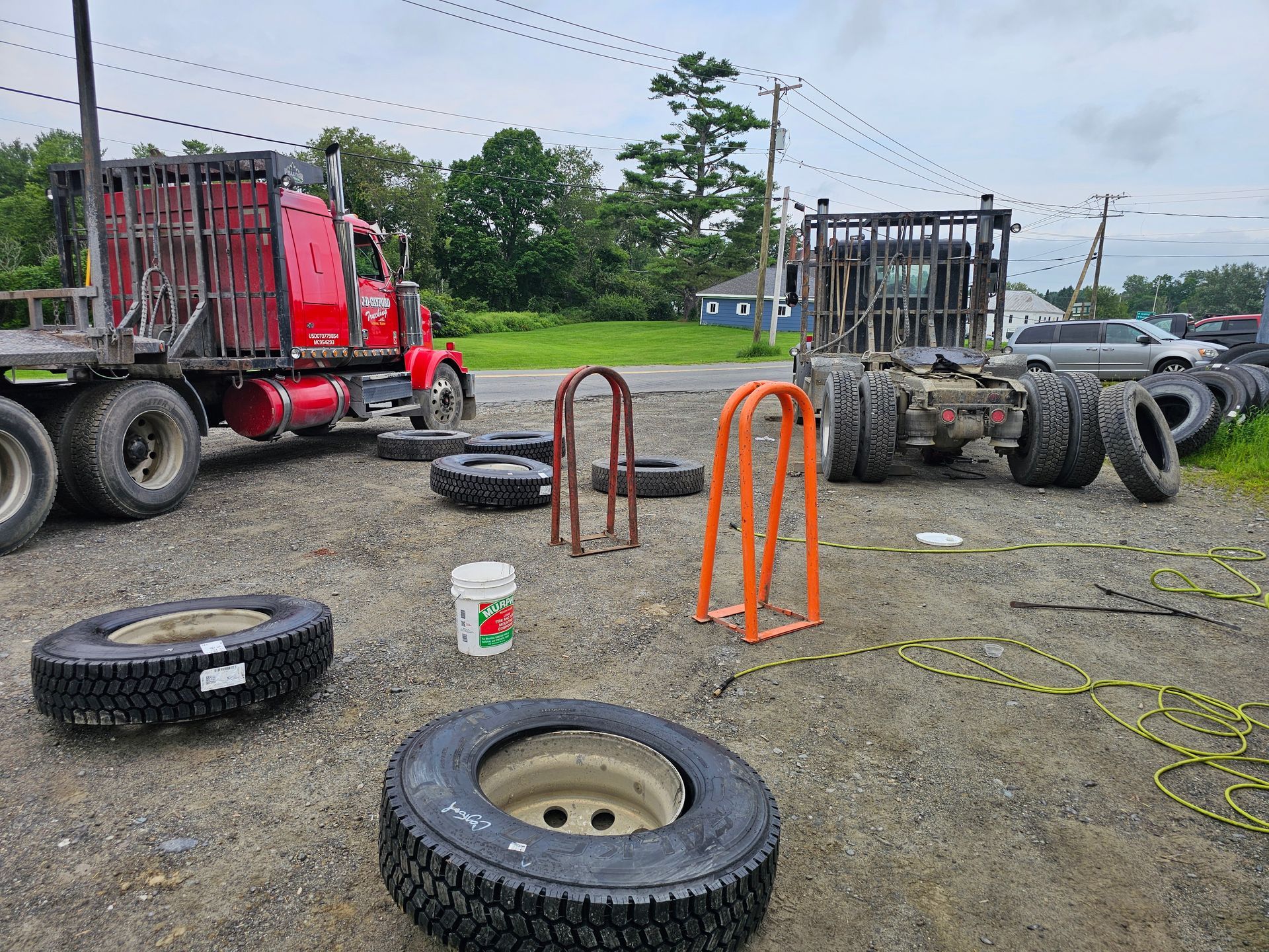 A truck is sitting in a parking lot surrounded by tires.