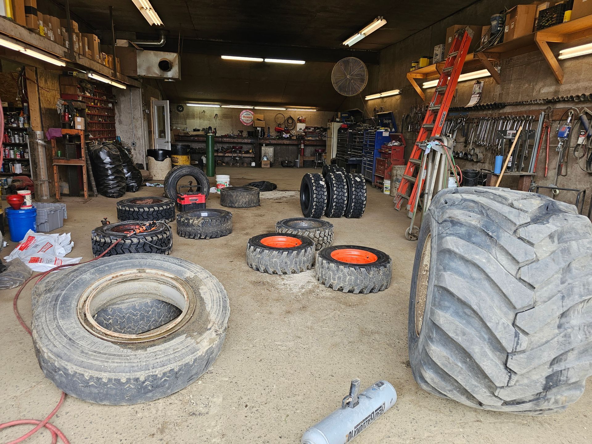 A garage filled with lots of tires and a ladder