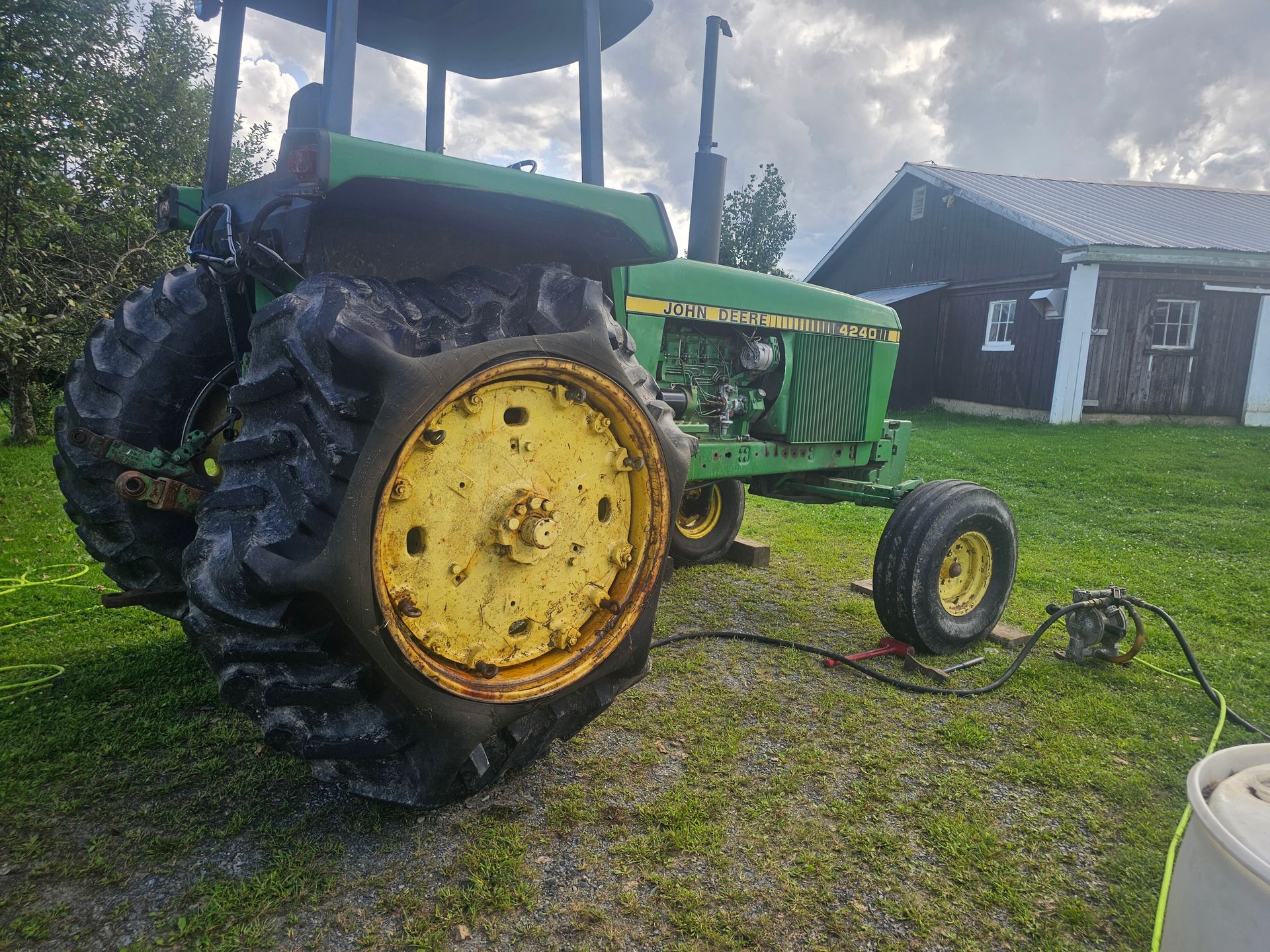 A green and yellow john deere tractor is parked in a grassy field.