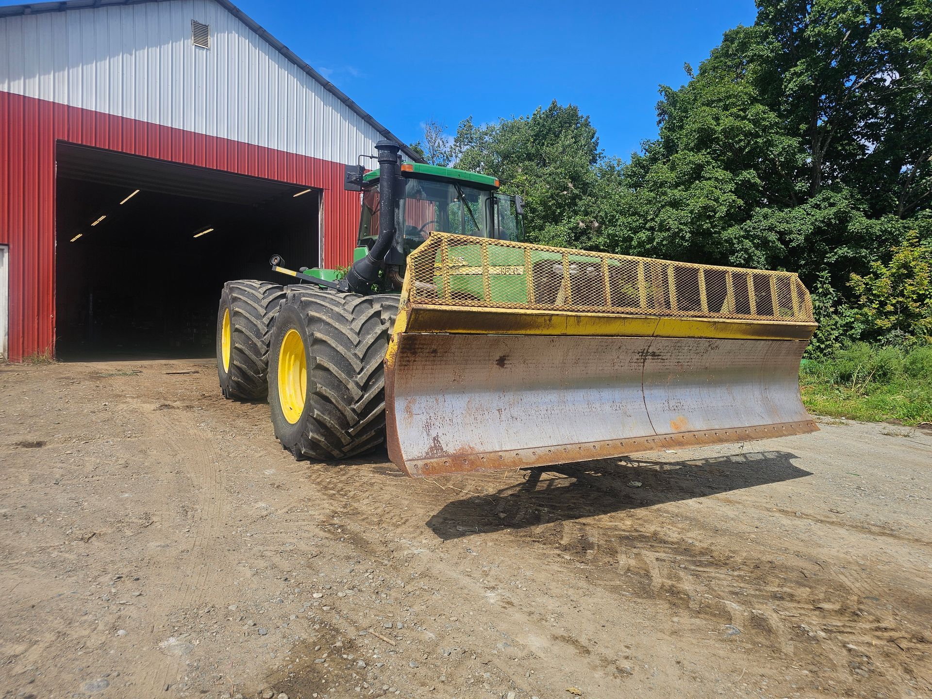 A john deere tractor is parked in front of a barn