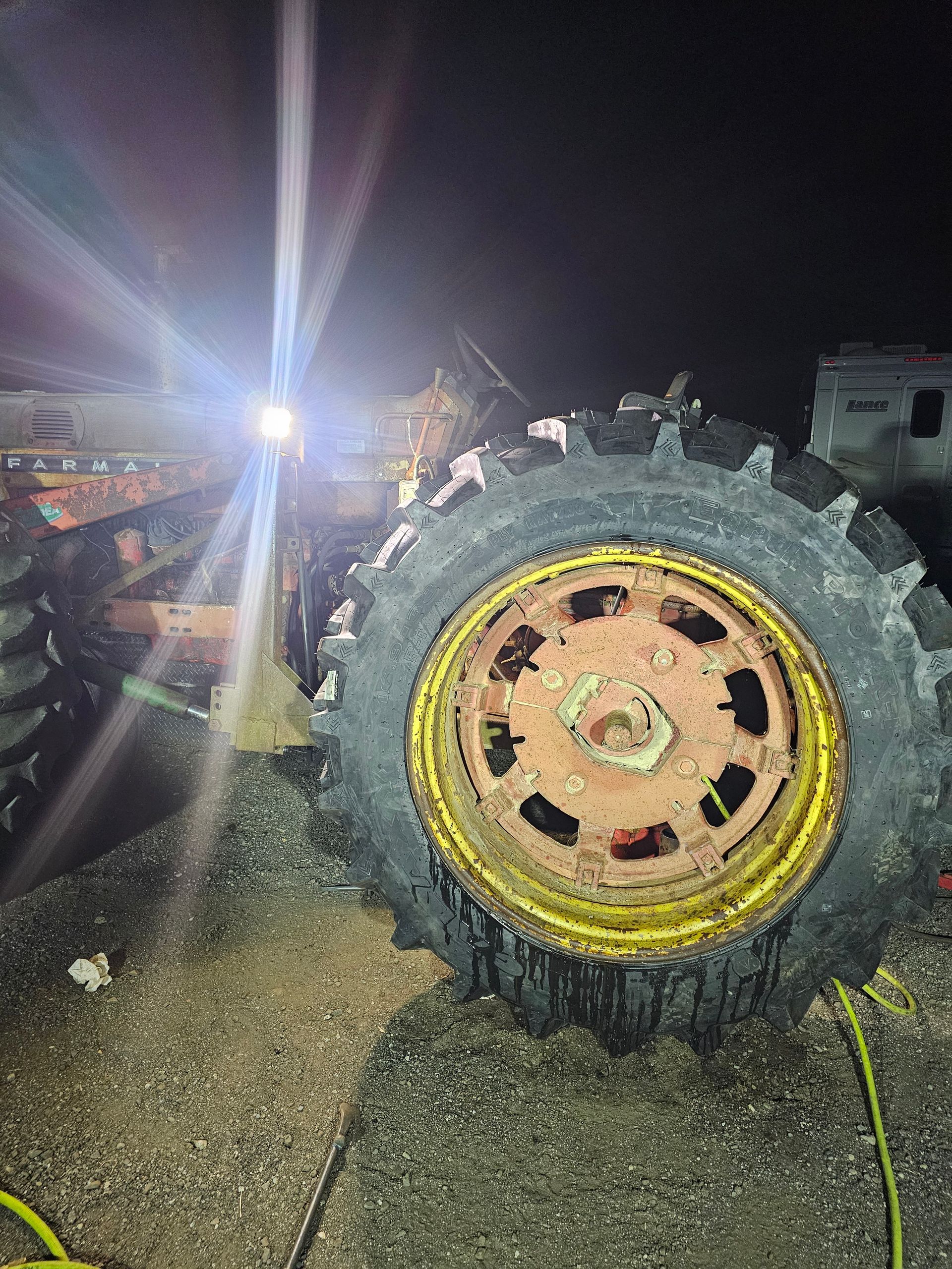 A close up of a tire on a tractor at night.
