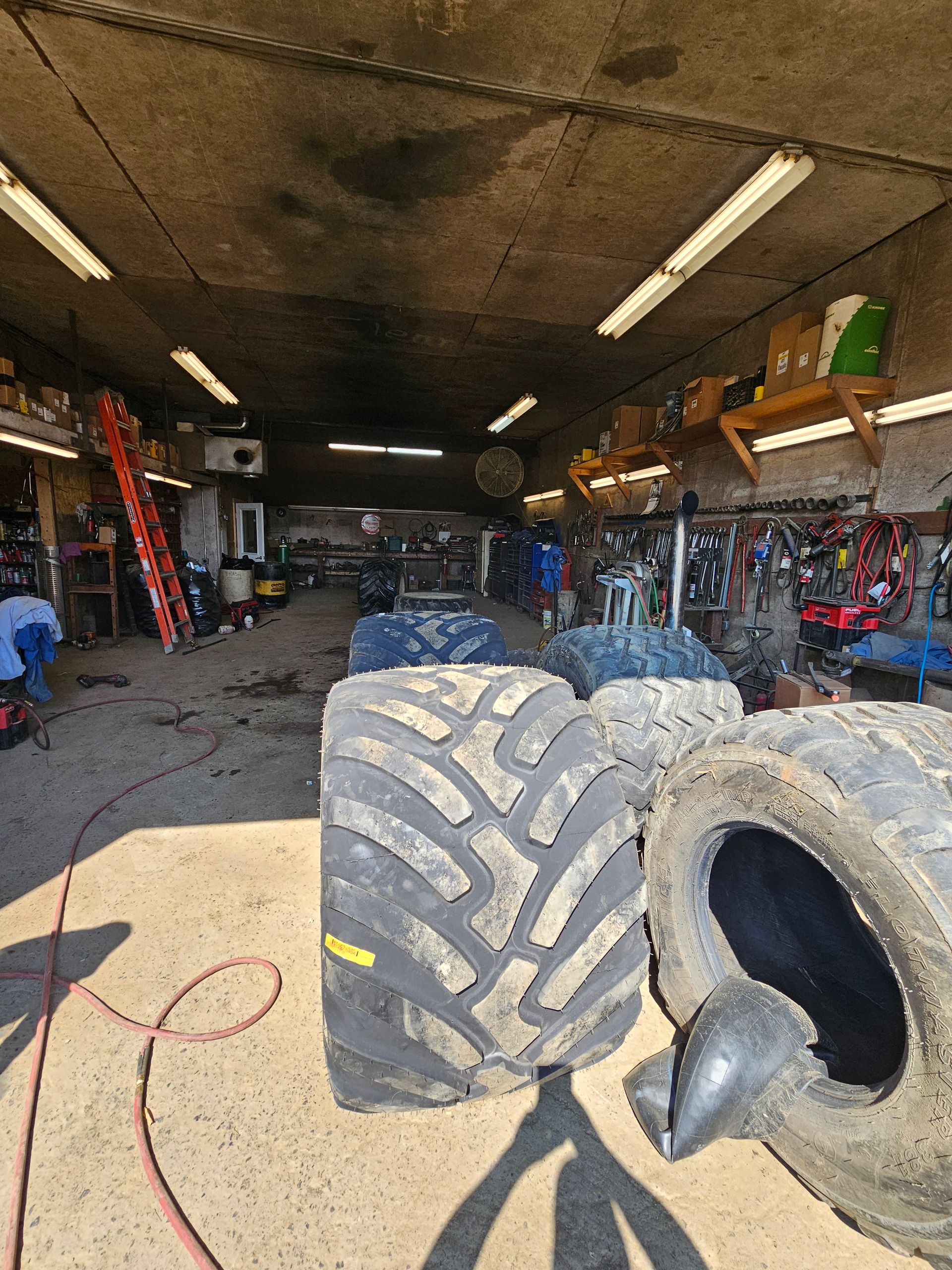 A couple of tires are sitting on a table in a garage.