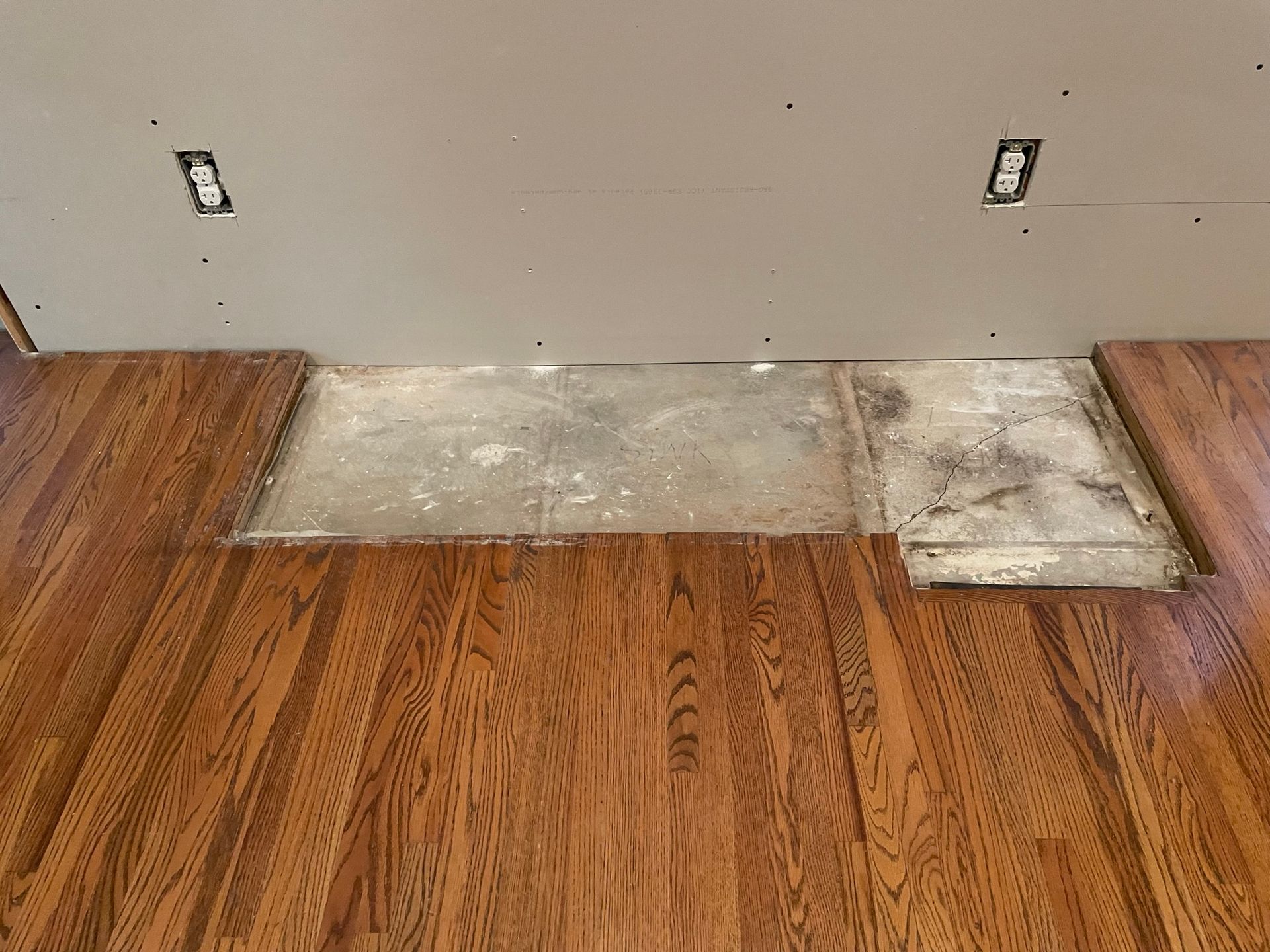 A wooden floor with a tile floor underneath it.