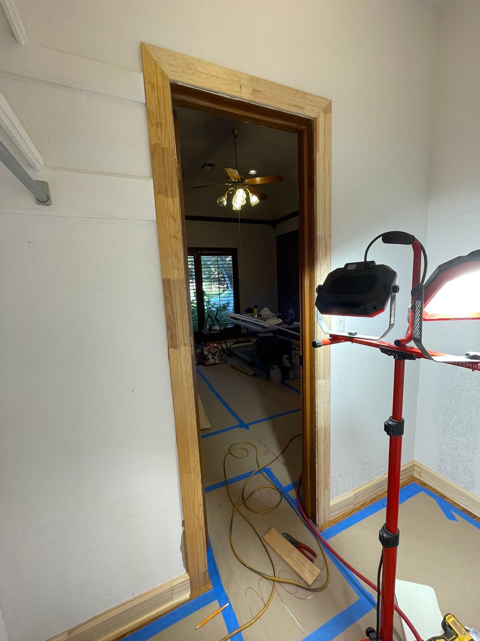 A door is being built in a room with a light on the floor.