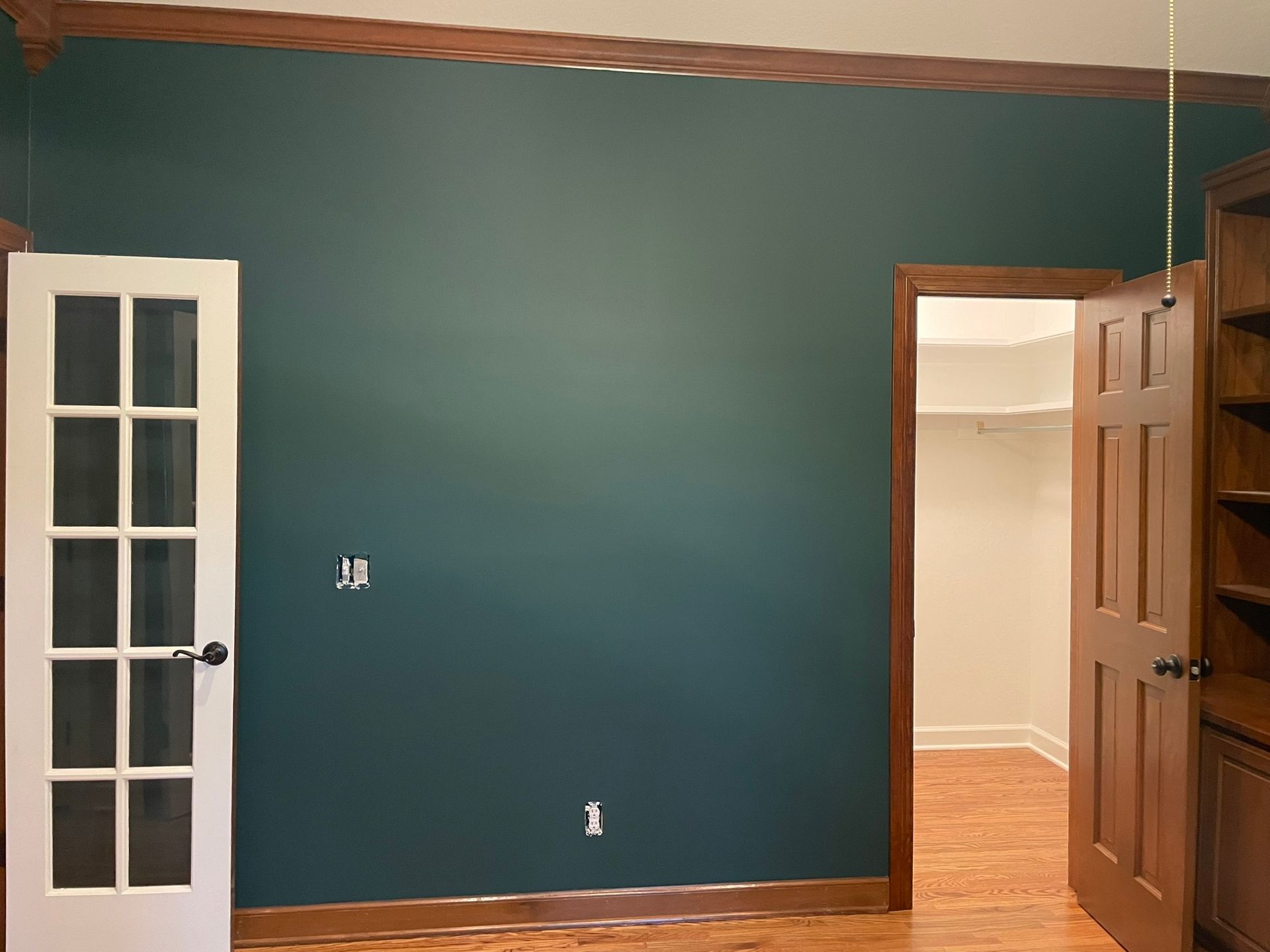 A room with a blue wall and a white door