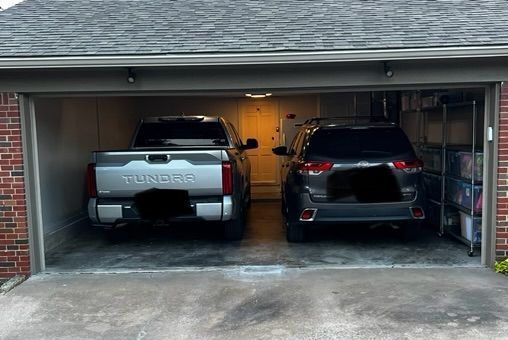 Two tundra trucks are parked in a garage.