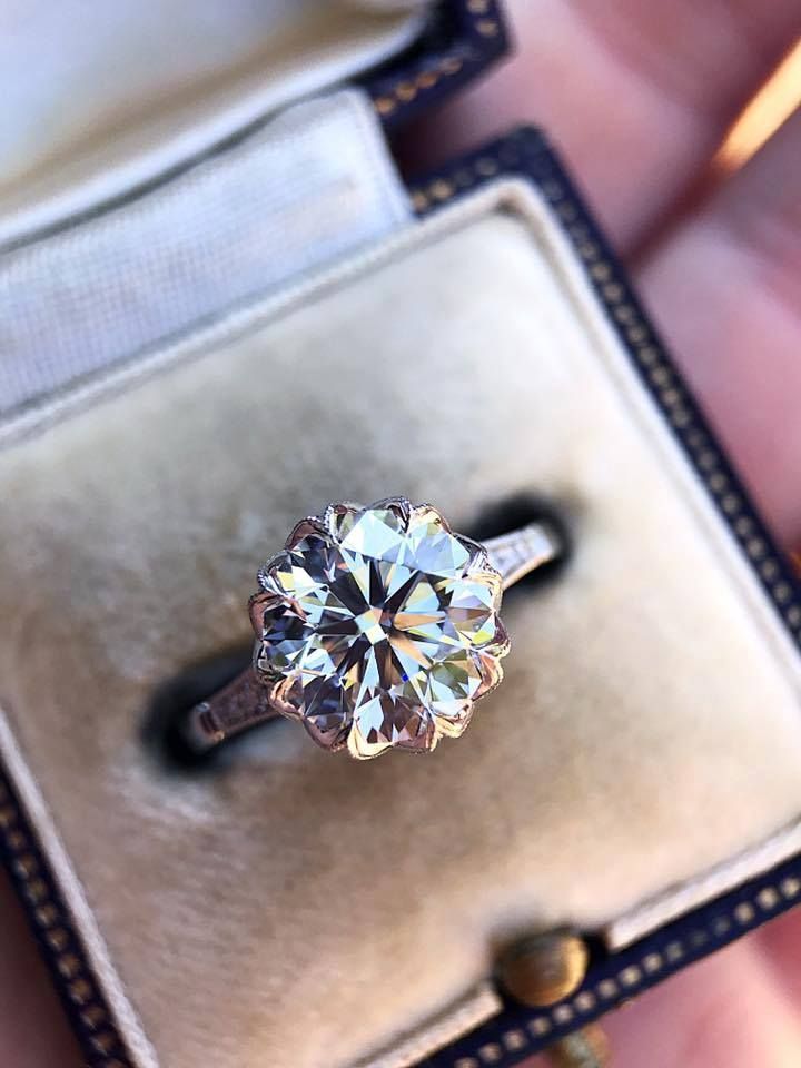 A person is holding a diamond ring in a box.