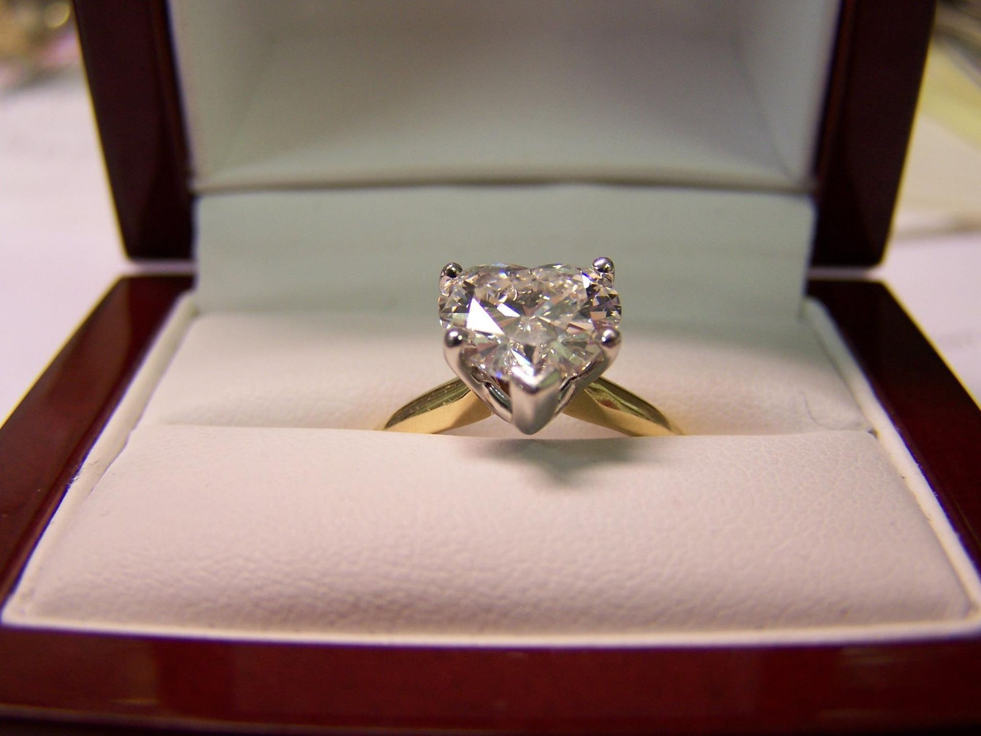 A heart shaped diamond ring in a box