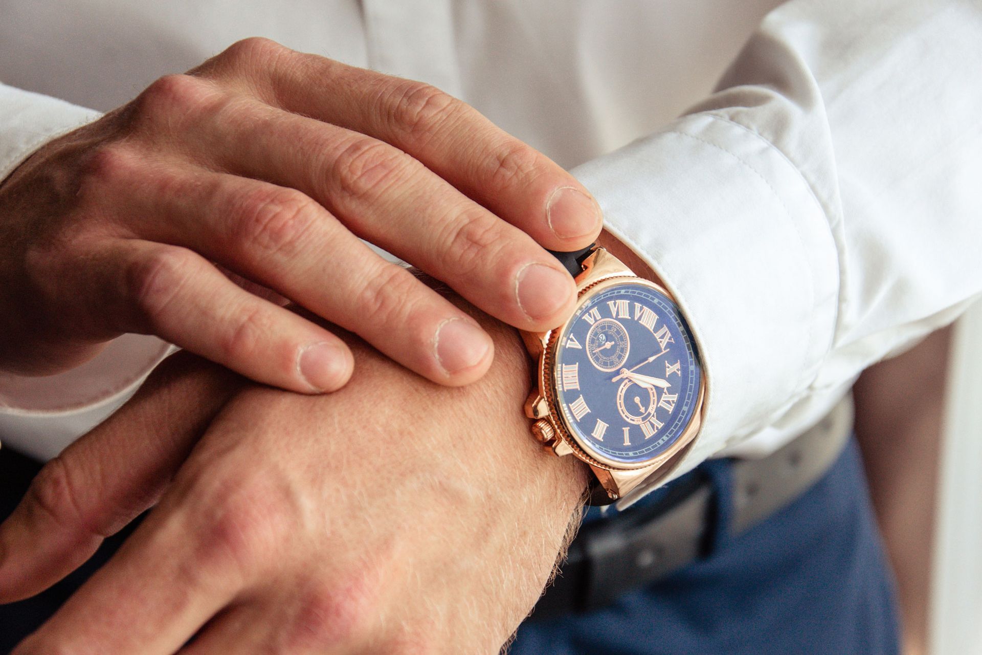A man is looking at his watch on his wrist.