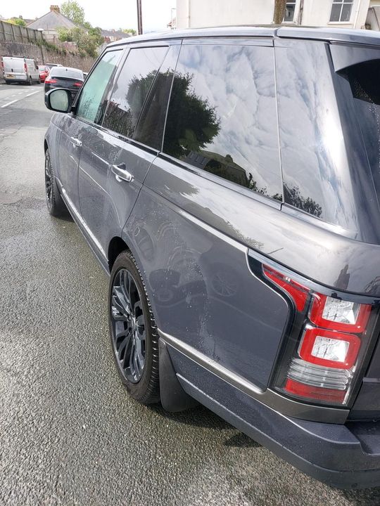 The interior of a range rover sport with white leather seats and a steering wheel has been detailed.