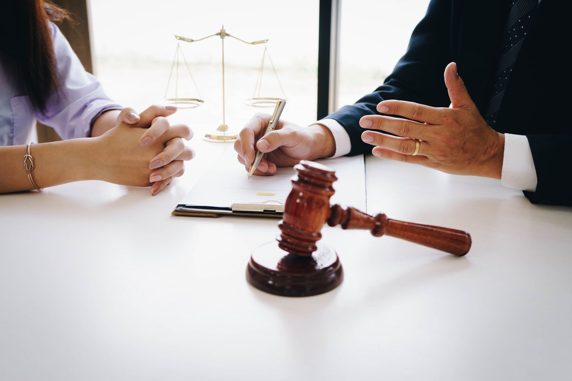 A man and a woman are sitting at a table with a judge 's gavel. A man and a woman are sitting at a table with a judge 's gavel.