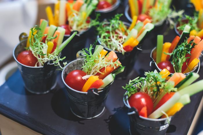 Beautifully decorated catering banquet table with variety of vegetables and different vegan vegetarian snacks on corporate christmas birthday party event or wedding celebration