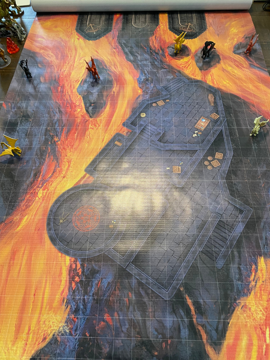 Battle map with lava, stone structure, and miniature figures.