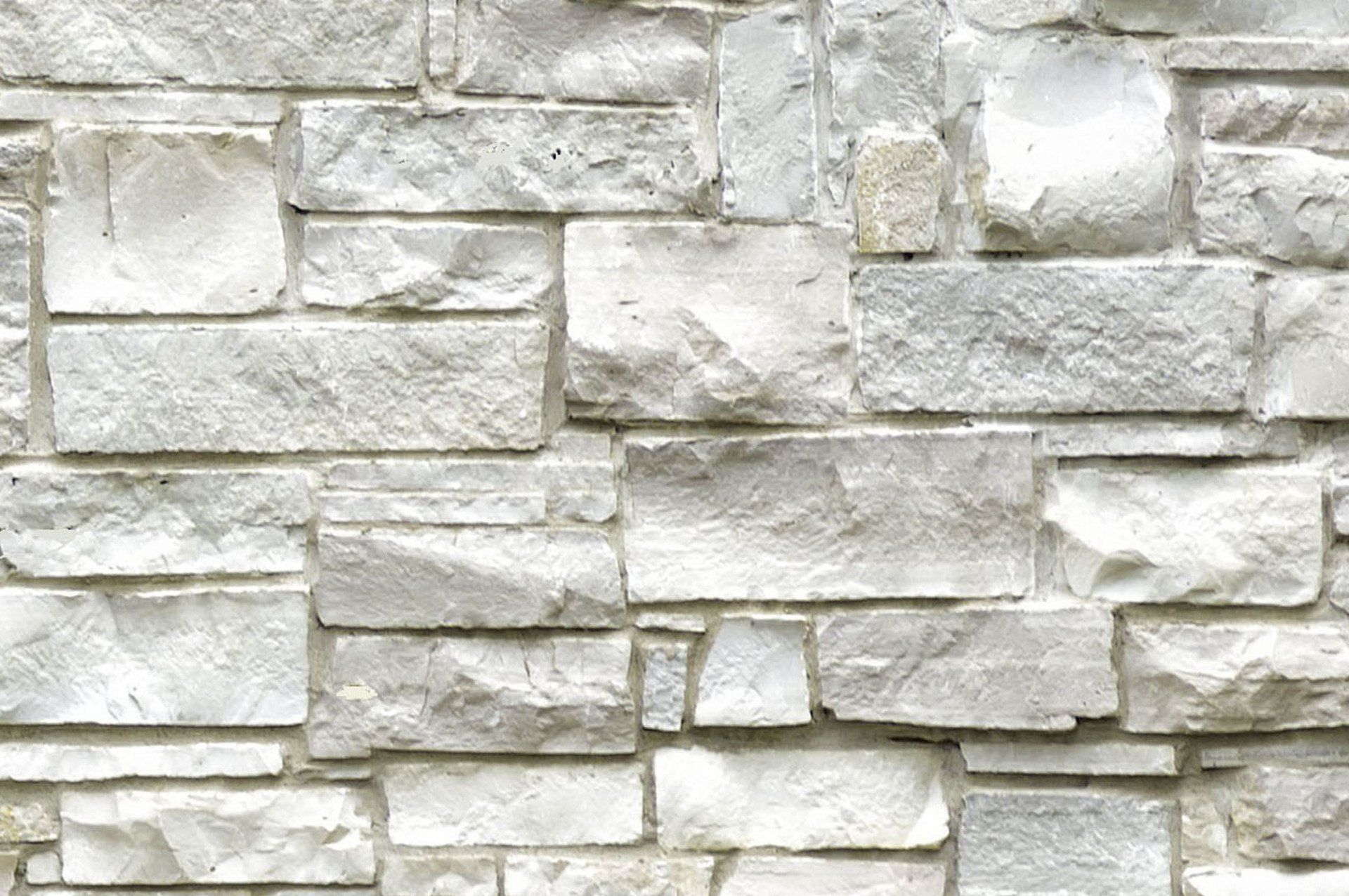 White stone wall with varied rectangular and square blocks. White stone wall with varied rectangular and square blocks.