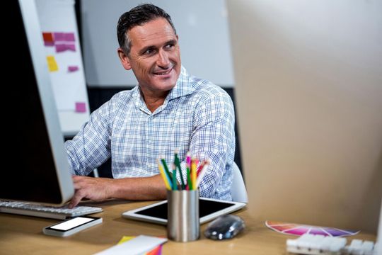 a man sitting at a desk in front of a computer
