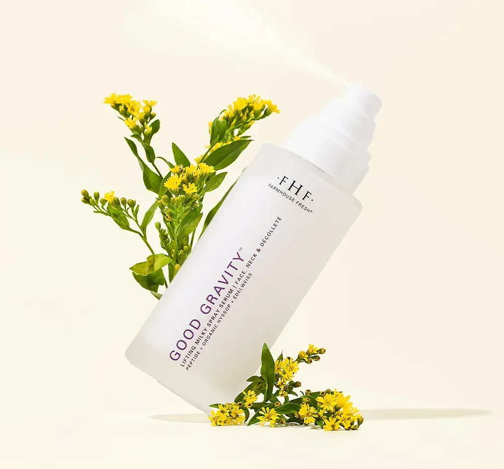 White skincare bottle labeled “GOOD GRAVITY” with yellow flowers on a light background
