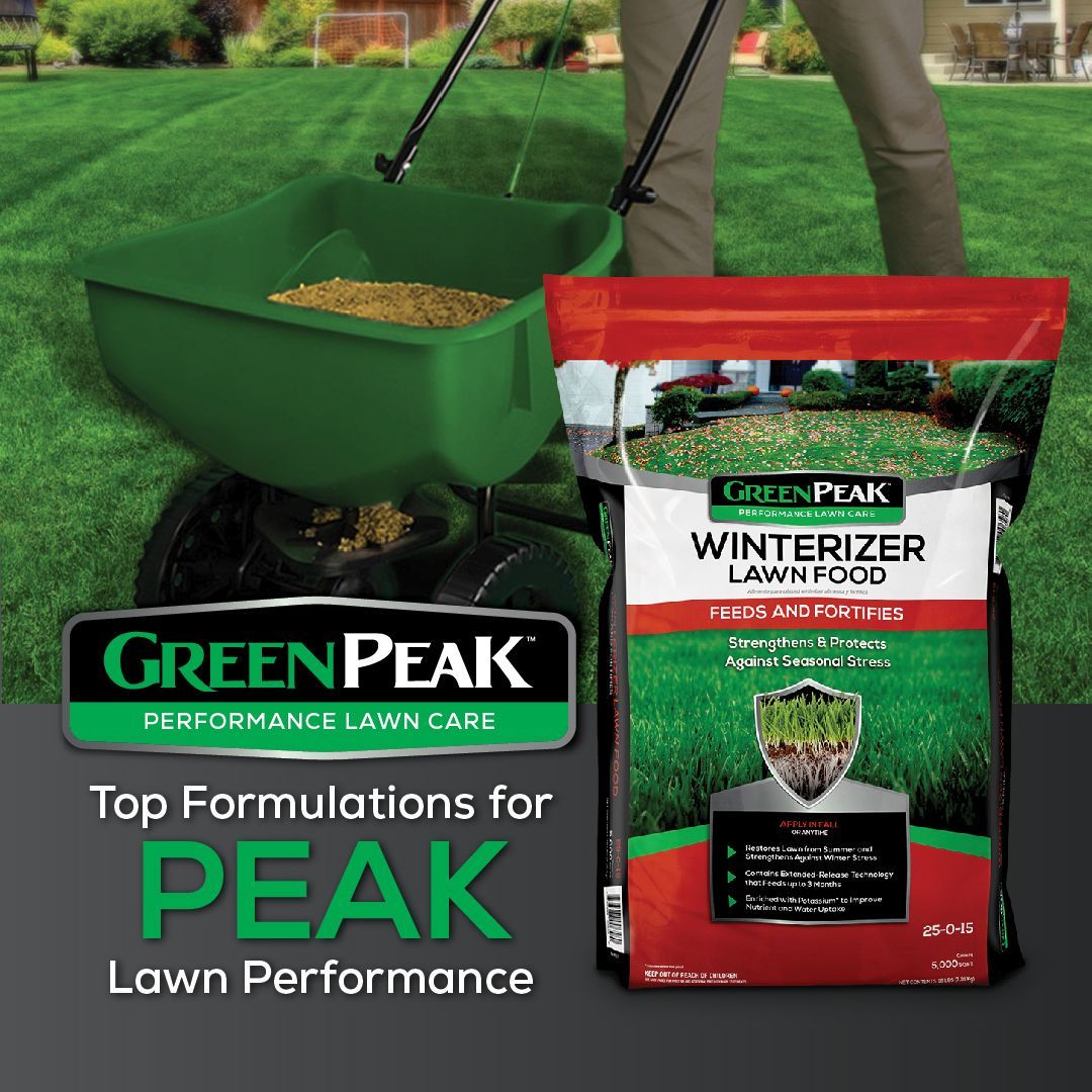 A person is spreading green peak winterizer lawn food on a lush green lawn