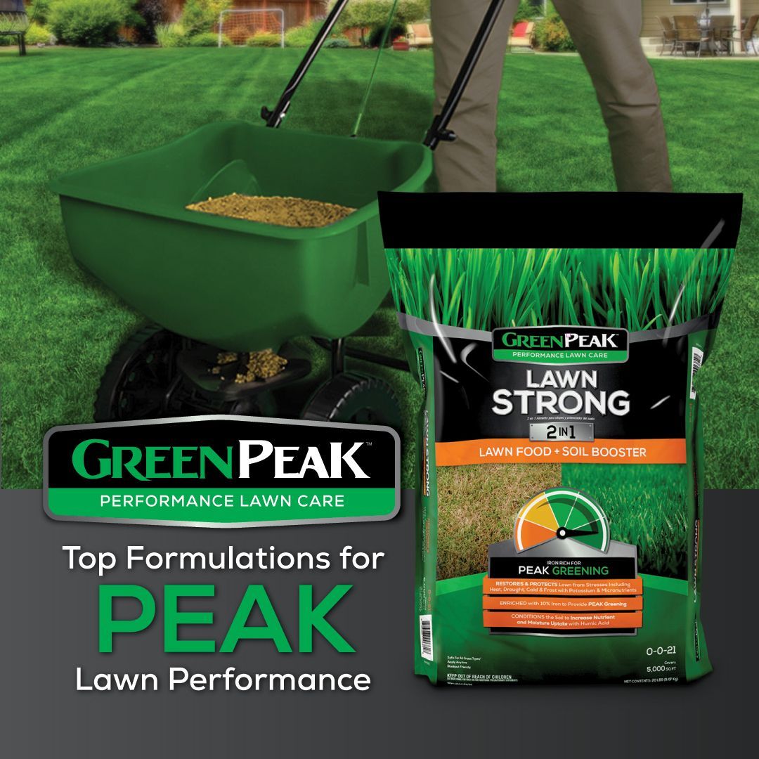 A bag of green peak lawn strong is being spread on a lush green lawn