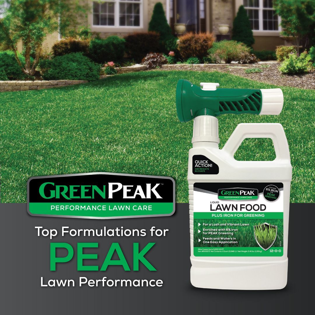 A bottle of green peak lawn food is sitting on top of a lush green lawn.
